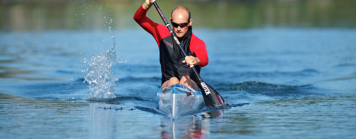 Man paddling on a calm day wearing Sharkskin Performance Wear