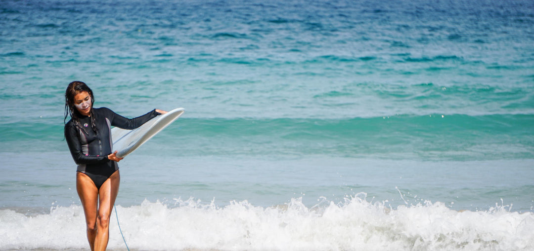 Female surfer wearing a Sharkskin Step in one piece